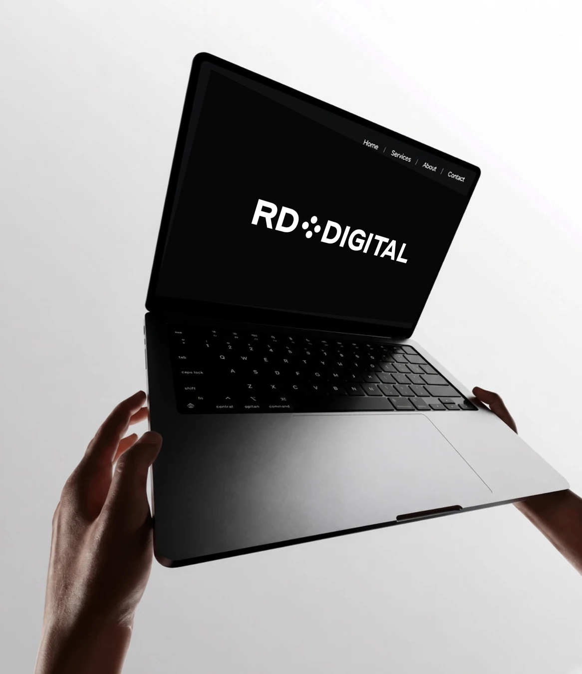 Laptop displaying the RD Digital website, held against a light background